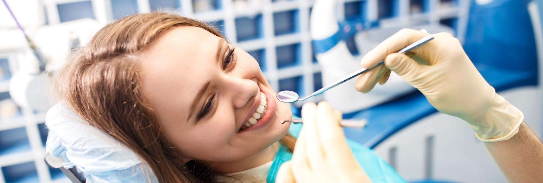 Female in a blue dental chair receiving a dental check up in Australia