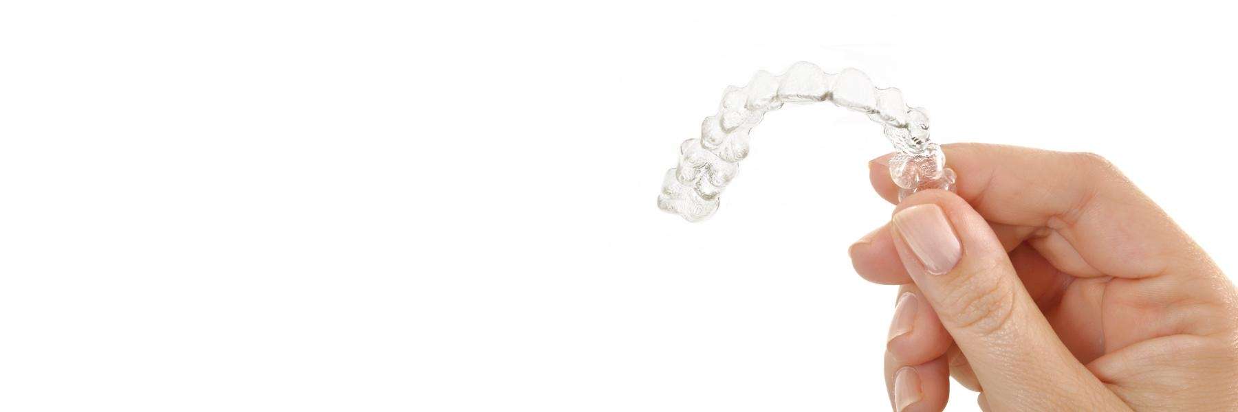 patient holding Invisalign aligner in black rock, VIC