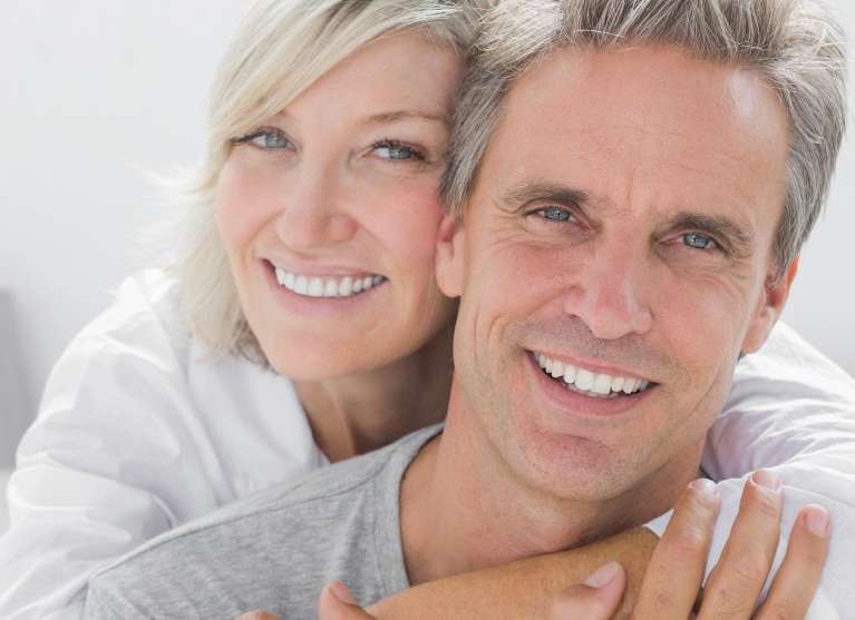 Cheerful smiling couple with white teeth hugging in Australia