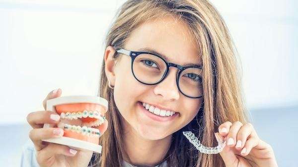 A teen deciding between Invisalign in Black Rock and braces