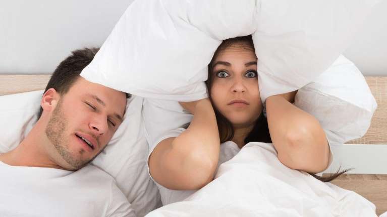 Wife covers her ears with pillow as her spouse snores in Black Rock VIC